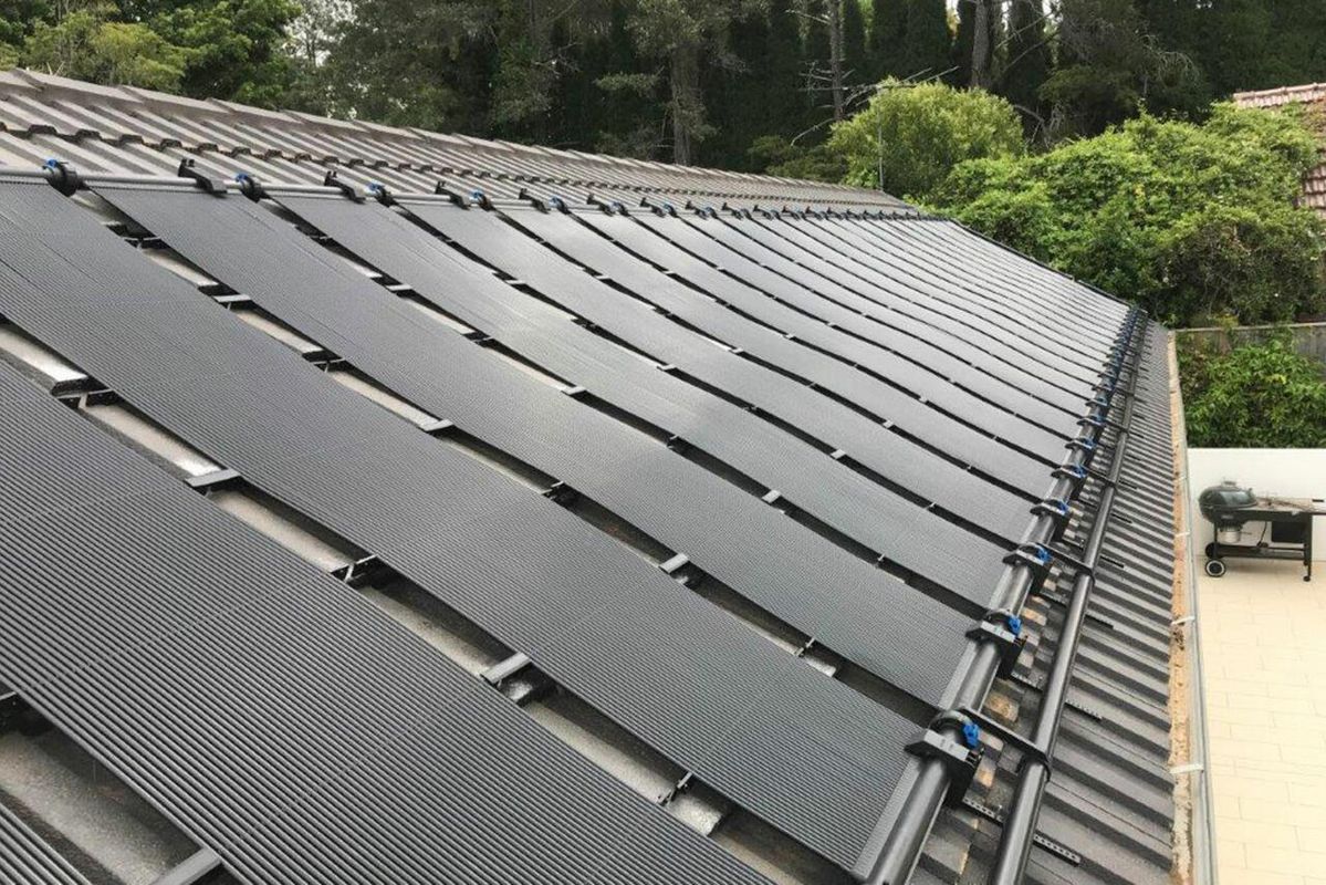 Coletores solares instalados sobre telhado para aquecimento de piscina